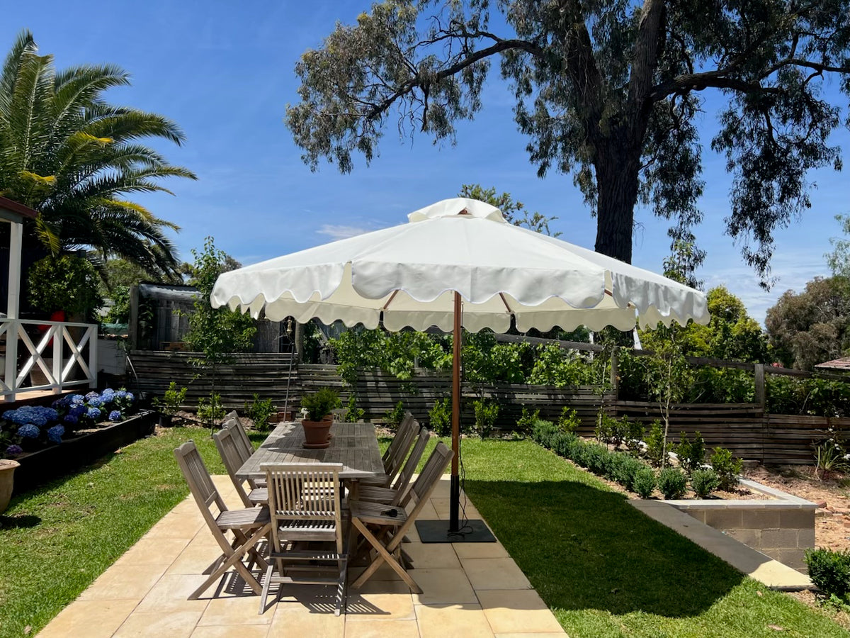 D.Dawson scalloped timber umbrella shading an outdoor dining setting